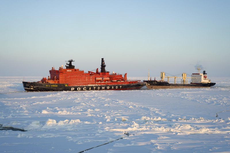 A Rosatomflot icebreaker escorting a cargo ship in Arctic ice. Illustration of escort practice — not identified as the insured hull.